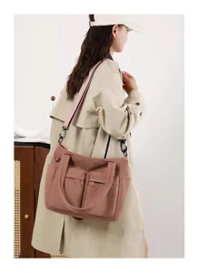 Side view of an Asian model wearing a dusty rose multi-pocket commuter canvas tote bag