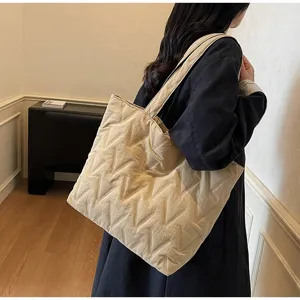 Vista lateral del bolso tote acolchado beige grande para mujer para el día a día.