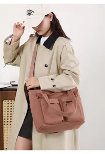 Stylish large dusty rose canvas tote bag with multiple pockets shown on woman model