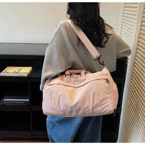 Lifestyle view of the pink large-capacity travel bag being carried over the shoulder