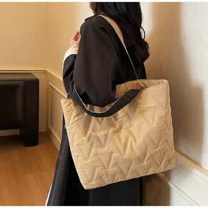 Vista lateral detallada de un bolso tote acolchado beige de gran capacidad para el trabajo