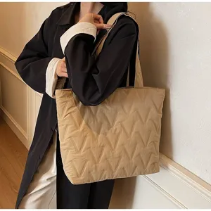 Foto de estilo de vida de mujer con un bolso tote acolchado caqui grande con diseño en V
