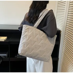 Vista trasera de un gran bolso tote acolchado blanco con patrón en V en el hombro