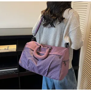 Large capacity purple travel bag with grid pattern shown being carried by a woman