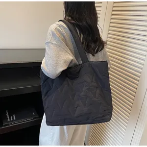 Bolso tote acolchado negro de gran capacidad en modelo dentro de interior moderno
