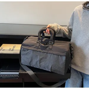 Detailed view of grey travel duffel bag with grid pattern and sturdy handle