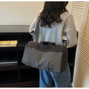 Large capacity checkered duffel bag for women shown as a shoulder bag in a lifestyle setting