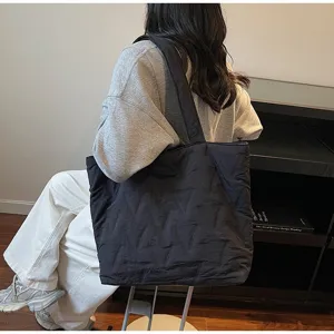 Bolso tote acolchado negro de gran capacidad en una vista de transporte natural