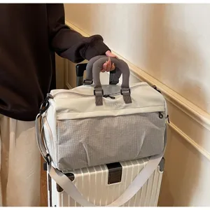 Large capacity travel bag on a suitcase showing handheld strap and grid texture