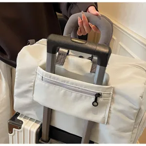 Detail view of lightweight travel bag featuring a functional trolley sleeve on a suitcase