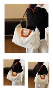Sac de voyage en toile blanche avec poignées orange porté par un mannequin.