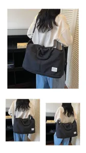 Détail d'un grand sac de voyage noir pliable avec bandoulière réglable et poignées.