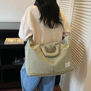 Grand sac de voyage pliable vert clair porté à l'épaule pour les voyages et le sport