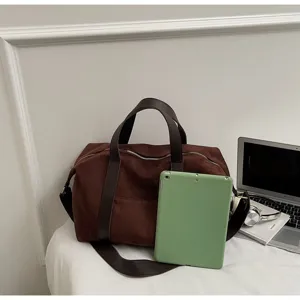 Grande borsa da viaggio in pelle scamosciata marrone con un tablet verde per scala