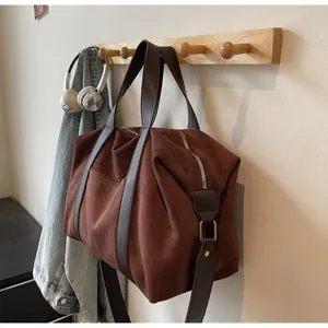 Borsa da viaggio vintage in pelle scamosciata marrone appesa a un appendino legno