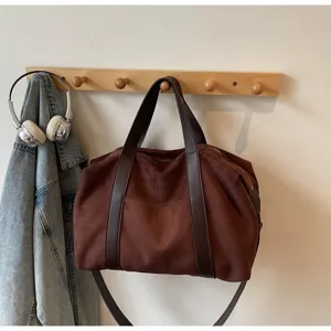Borsa tote da viaggio in pelle scamosciata appesa a un appendiabiti.