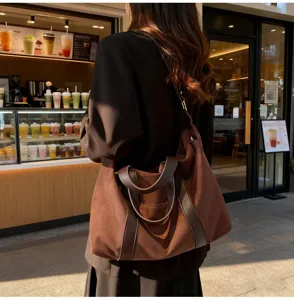 Grande borsa tote vintage con patchwork in pelle in un ambiente accogliente di un bar cittadino