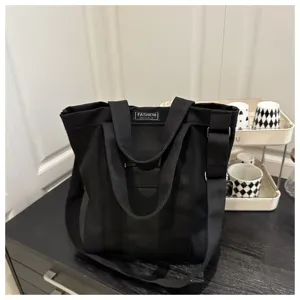 Minimalist black vintage canvas tote bag with adjustable shoulder strap