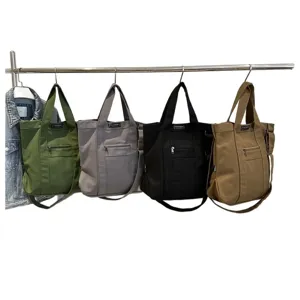 Versatile vintage canvas tote bags in four colors hanging on a metal rack display