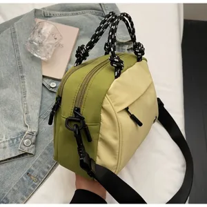 Detail view of the lightweight multi-layer nylon crossbody bag in green and yellow