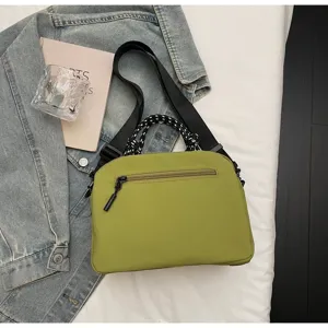 Macro view of lightweight olive green nylon crossbody bag with black rope handle details