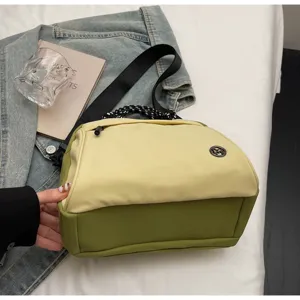 Two-tone beige and olive green crossbody bag with black strap and 'M' logo detail