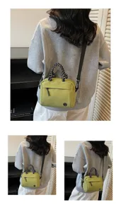 Back view of a chic olive green crossbody bag with stylish braided handles