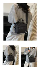 Close-up view of black multi-layered crossbody bag styled with casual grey sweatshirt