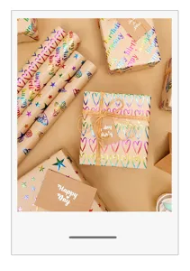 Detalle de papel de regalo kraft con patrones de corazones y estrellas bronceados