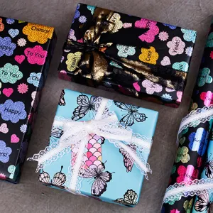 Diverse gekleurde rollen en dozen cadeaupapier met laser- en vlinderpatronen set