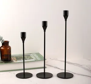 Driedelige set strakke zwarte minimalistische kandelaars op een marmeren tafelblad
