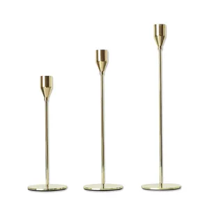 Set van drie elegante slanke gouden ijzeren kandelaars in verschillende hoogtes voor decoratie.
