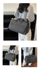 Detailansicht der schwarzen Karoreisetasche mit praktischen Griffen und Schultergurt.