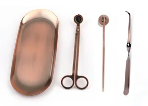 Close-up of rose gold stainless steel candle tool set with tray and wick trimmer