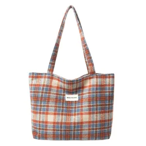 Bolso tote casual de lana con cuadros naranjas y azules con correas para el hombro.
