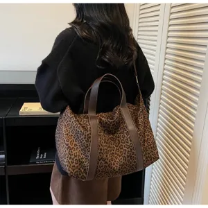 Grande borsa da viaggio leopardata alla moda con spalline marroni portata a spalla