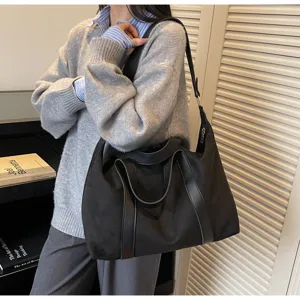 Vista dettagliata di una grande borsa tote nera vintage indossata da una modella in posa