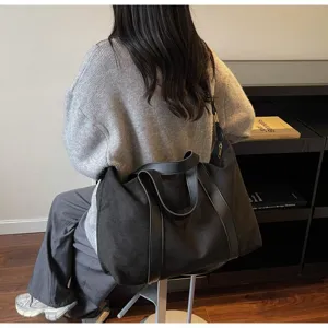 Vista dettagliata di una grande borsa da viaggio in camoscio nero con spalline in pelle
