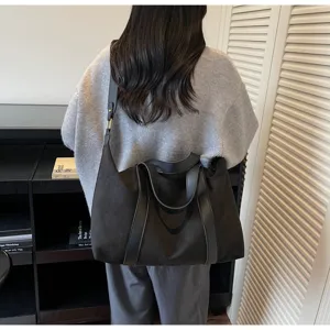 Grande borsa tote in pelle scamosciata nera indossata da una modella