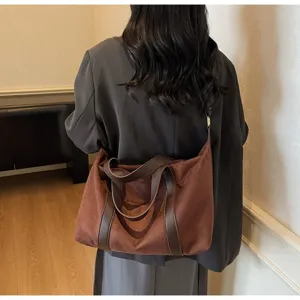 Vista dettagliata di una borsa tote vintage marrone di grande capacità portata a spalla