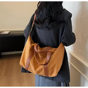 Grande borsa tote vintage color cuoio indossata da una modella in un ambiente interno moderno.