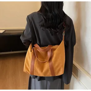 Vista posteriore di una modella con borsa tote grande in pelle scamosciata gialla e marrone