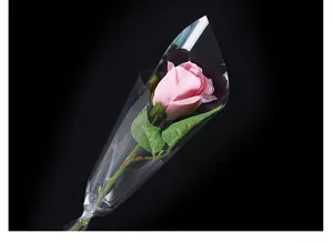 Enkele roze roos verpakt in heldere waterdichte OPP-folie voor bloemengeschenken.