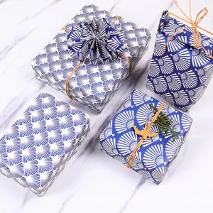 Papel de regalo elegante con patrón de abanico japonés azul sobre mármol blanco