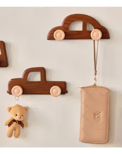 Close-up of decorative car-shaped wooden wall hooks for a cute children's room setup