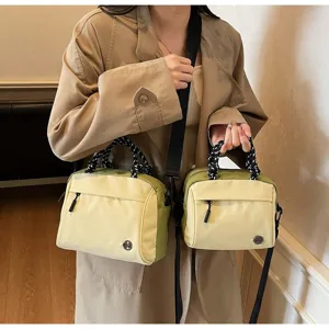 Detailed view of two light yellow and green crossbody bags in different sizes