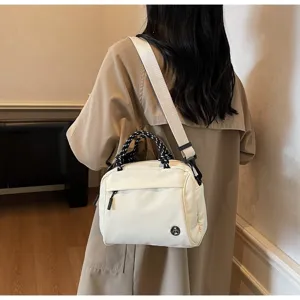 Modern white nylon shoulder bag worn by a woman in a beige trench coat backdrop