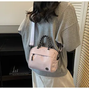 Stylish casual pink nylon crossbody bag with braided rope handles and adjustable strap