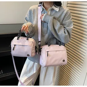 Detail view of two sizes of lilac nylon shoulder bags with patterned rope handles
