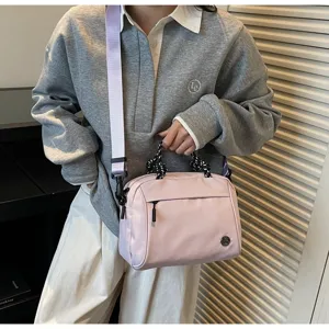 Lifestyle shot of a pink minimalist crossbody bag with lavender strap